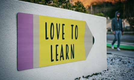 love to learn pencil signage on wall near walking man